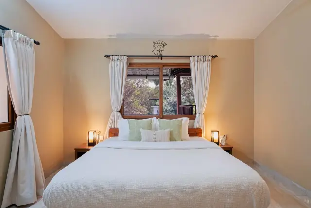 King bedroom with white linen and timber window
