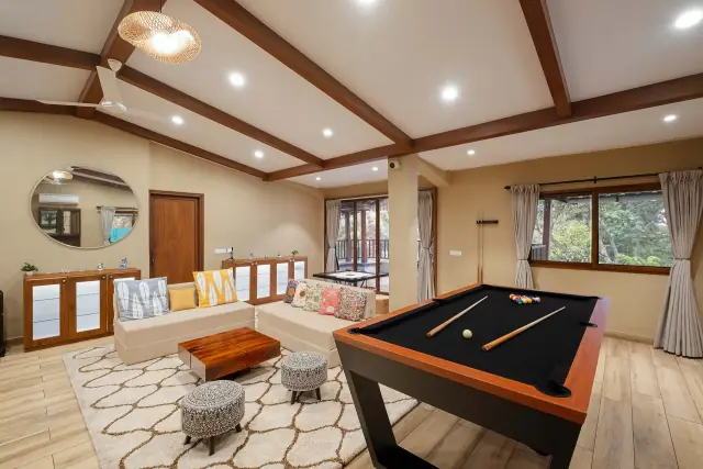 Games lounge with a pool table under timber beams