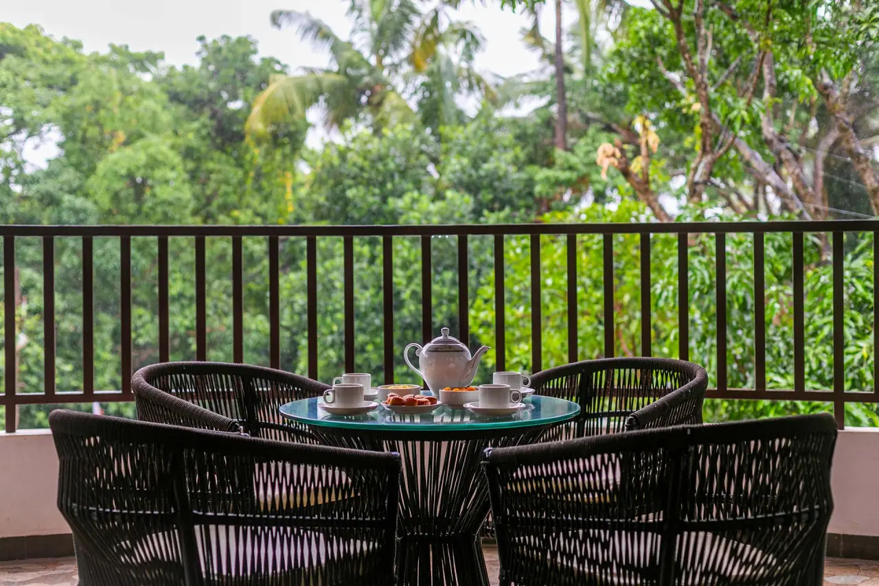 Balcony table set for tea, facing the trees